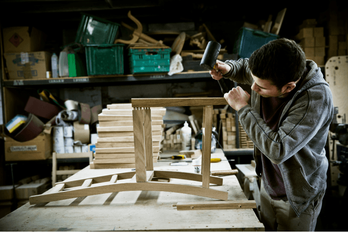 a-man-working-in-a-furniture-makers-workshop-assem-KRAEXN3 2