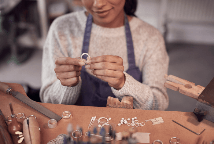 close-up-of-female-jeweller-at-bench-checking-ring-UXBC85K 2